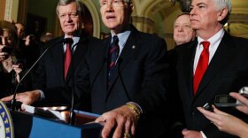 Senate Majority Leader Harry Reid of Nevada  (center) answers questions outside the Senate chambers Thursday after the Senate passed the health care reform bill. With Reid are (from left) Senate Finance Committee Chairman Max Baucus, Senate Majority Whip Richard Durbin, and Senate Banking Committee Chairman Christopher Dodd.