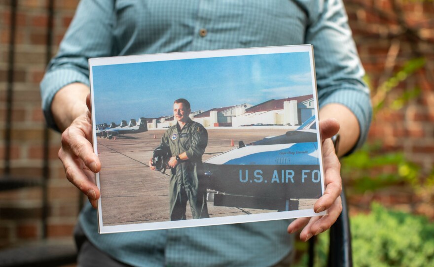 Bob Alexander, a retired lieutenant colonel in the U.S. Air Force, holds up a photo of when he was enlisted.
