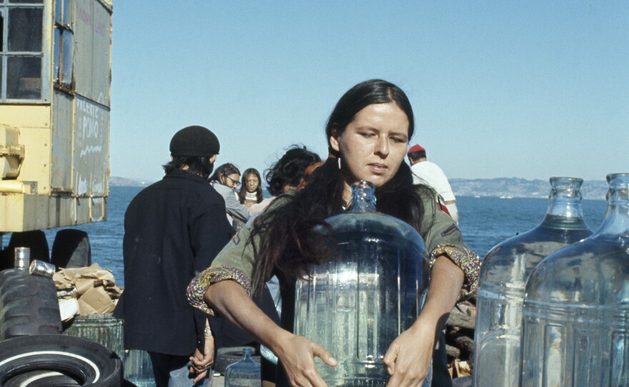 A young woman sets up large bottles of drinking water on Alcatraz Island on Nov. 17, 1970. This was part of a 19-month-long occupation by Native American activists in protest of U.S. government policies on treaties.