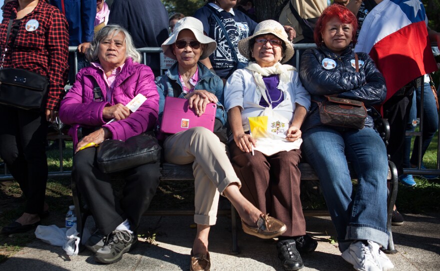 Women stake a claim along Constitution Avenue to catch a glimpse of Pope Francis during the papal parade in Washington, D.C.