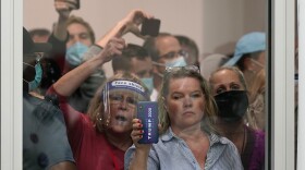 People wanting to be election challengers yell as they look through the windows of the central counting board as police were helping to keep additional challengers from entering due to overcrowding, Wednesday, Nov. 4, 2020, in Detroit. 