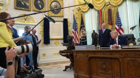 President Donald Trump answers questions from reporters after signing an executive order in the Oval Office of the White House Tuesday, March 31, 2026, in Washington, as Commerce Secretary Howard Lutnick listens.