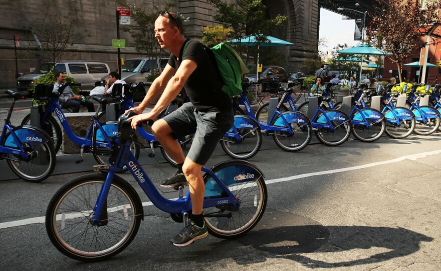 A major supplier to bike-sharing companies declared for bankruptcy this week — but experts say they still see the services spreading. Here, a man rides a Citibike through the Dumbo district of Brooklyn.