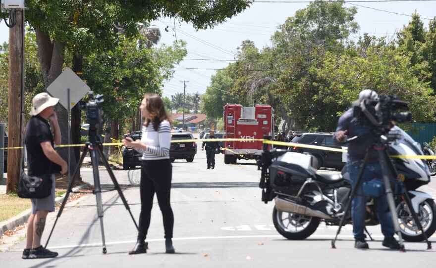 Media crews report on a shooting at the San Diego Islamic Center as first responders work in the background at the corner of Batista and Aeon May 18, 2026.