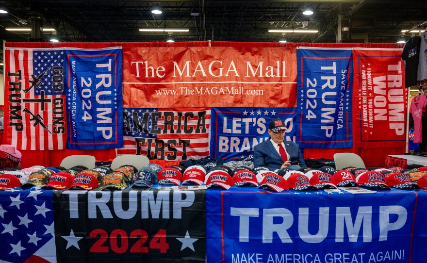 A vendor sits with their Trump-themed merchandise at CPAC.