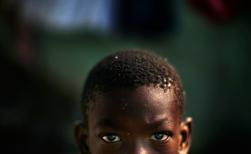 Alex Mertulus, age 10, the son of Magarette Brutus, stands in the mud in the Mais Gate Camp after heavy rains flooded the area in the middle of the night in Port-au-Prince. Both Magarette and her son Alex are fighting a loosing battle of moving around to different IDP camps trying to find a place were they can live.