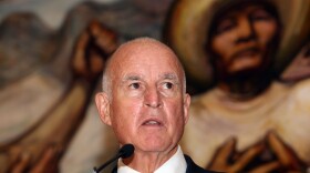 Backdropped by a mural by Mexican painter David Alfaro Siqueiros, California Gov. Jerry Brown speaks during a press conference at the Soumaya museum in Mexico City, July 28, 2014. 