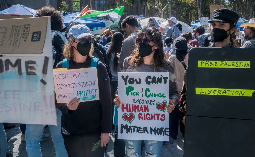 Pro-Palestinian protesters hold signs outside the Gaza solidarity encampment at UC San Diego, May 5, 2024.