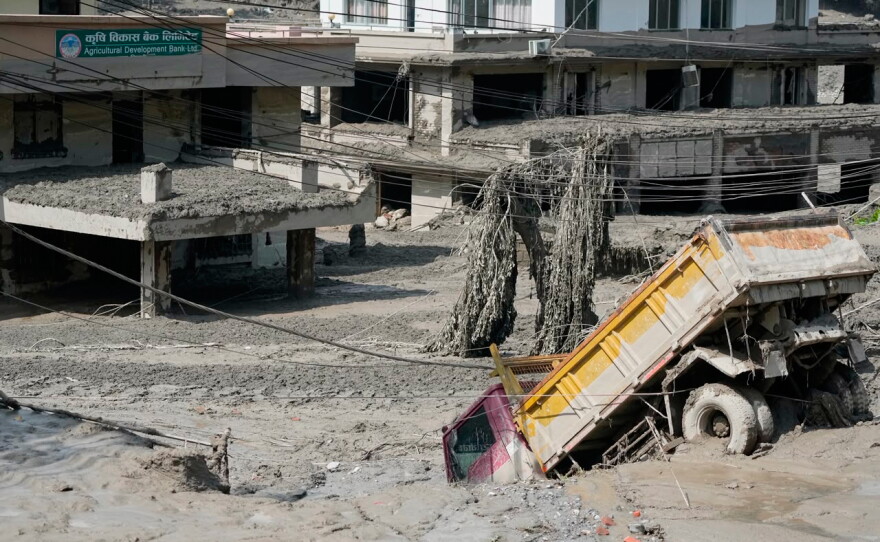 Damaged houses and vehicles are seen in the aftermath of flash floods along the Trishuli River in Nepal's Nuwakot district, Wednesday, Aug. 26, 2026.