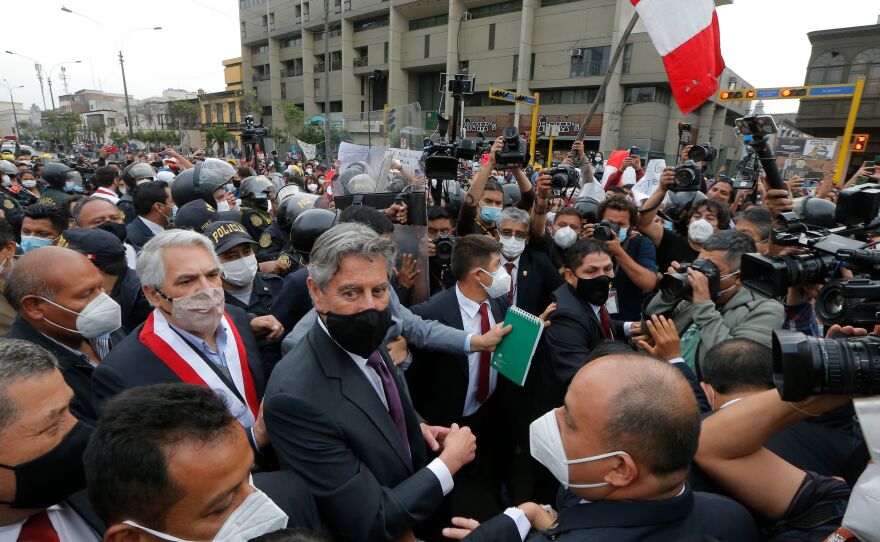 Francisco Sagasti, center with black mask, leaves the Congress in November after being chosen as the country's interim President. Sagasti was the third president in the span of a week. Political instability has hampered Peru's efforts to get vaccines.
