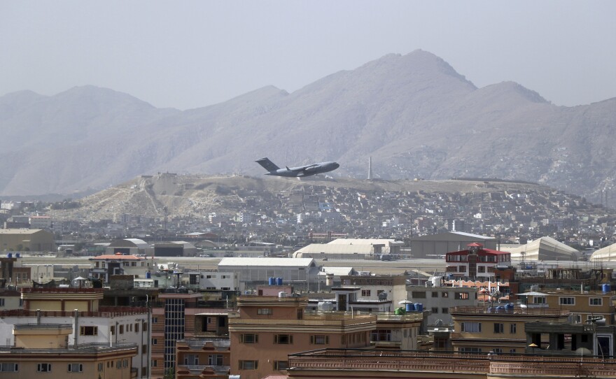 A U.S. military aircraft takes off at the Hamid Karzai International Airport in Kabul, Afghanistan, Saturday. President Biden warned another attack at the airport is "highly likely."