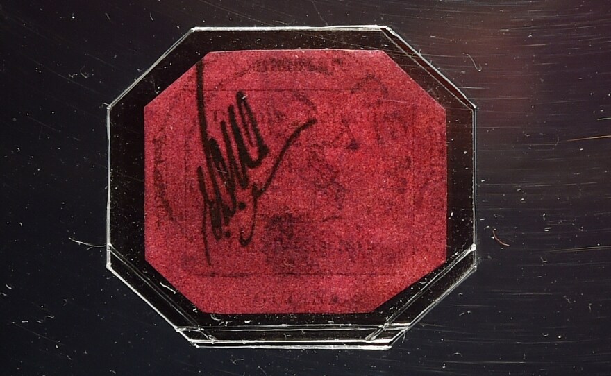 Measuring 1 inch-by-1.25 inches, the "British Guiana One-Cent Magenta On Black" bears the image of a three-masted ship and the colony's motto in Latin: "We give and expect in return."