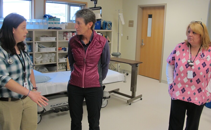 Bonita Babcock (right) looks on as a physician assistant at the clinic in King Cove, Alaska, explains to Interior Secretary Sally Jewell how a road from King Cove to Cold Bay would improve health care.