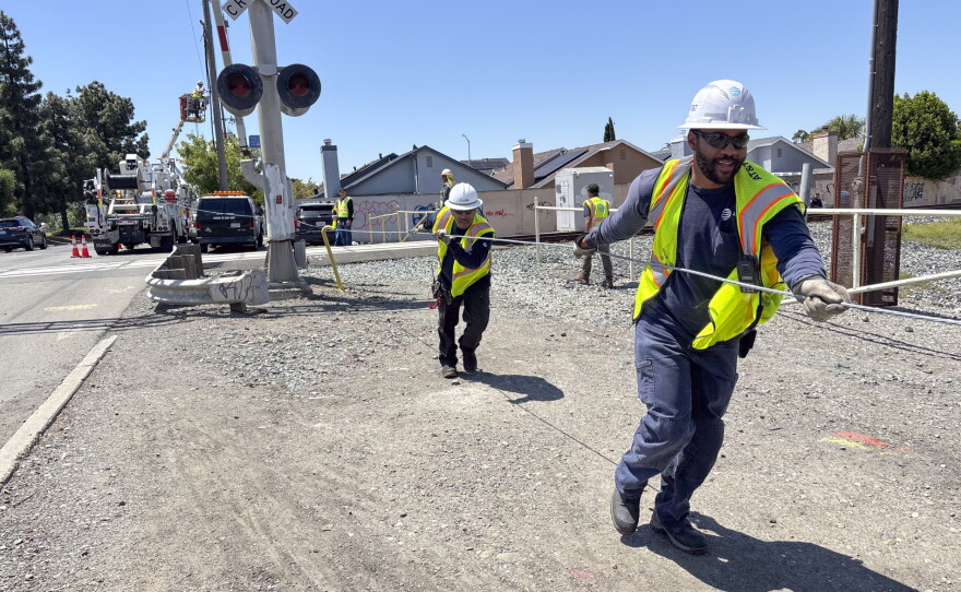 An AT&T crew installs a new cable at a railroad crossing in Hayward, Calif., after the segment got cut down by suspected copper wire thieves.