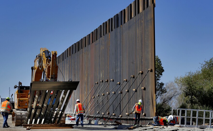 Government contractors erect a section of a Pentagon-funded border wall along the Colorado River in Yuma, Ariz., on Sept. 10.