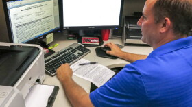 An unidentified Immigration and Customs Enforcement, ICE deportation officer reviews forms required to issue a detainer asking local law enforcement to hold someone until ICE agents can pick the person up, Aug. 31, 2015. 