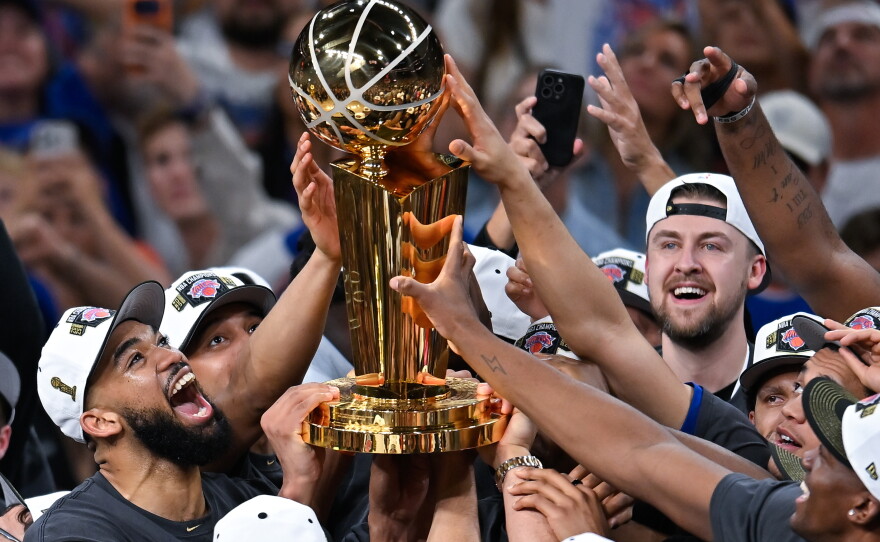 The New York Knicks celebrate with the Larry O'Brien Championship Trophy after defeating the San Antonio Spurs in Game 5 of the NBA Finals basketball series, Saturday, June 13, 2026, in San Antonio. (AP Photo/Darren Abate)