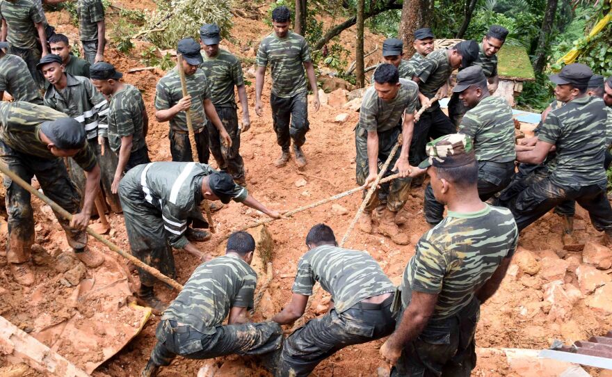 Sri Lankan military personnel work on rescue operations in the village of Bulathkohupitiya on Wednesday. Three days of torrential rain led to landslides in central Sri Lanka.