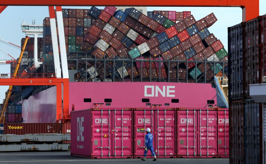A worker walks past the ONE Apus container ship and its dislodged containers at the Kobe Port in Japan, in December. The vessel suffered a massive stack collapse and lost 1,816 containers at sea during severe weather on Nov. 30.