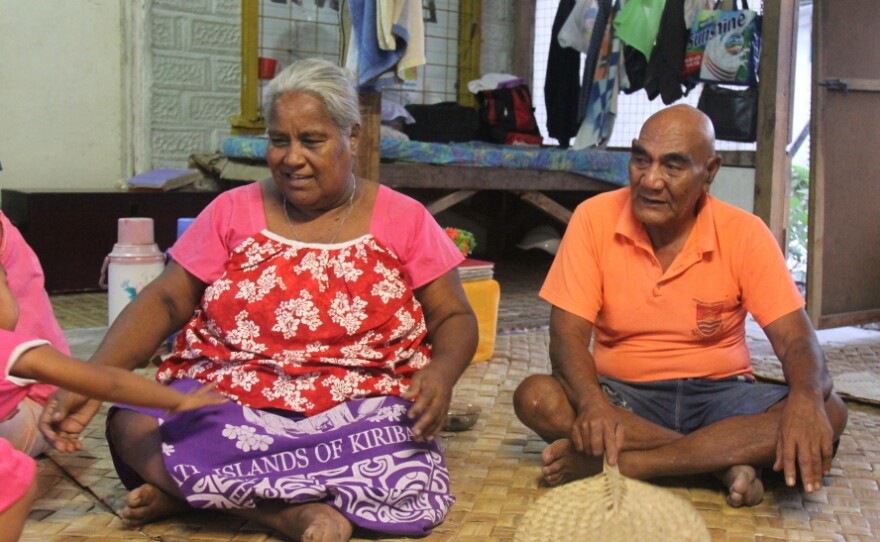 Batie Tebwa and Baure Karakaua sit on the floor of their home in Kiribati. Their daughter, Tiibea Baure, has repeatedly tried to convince them that climate change is a threat, but they don't believe in it.