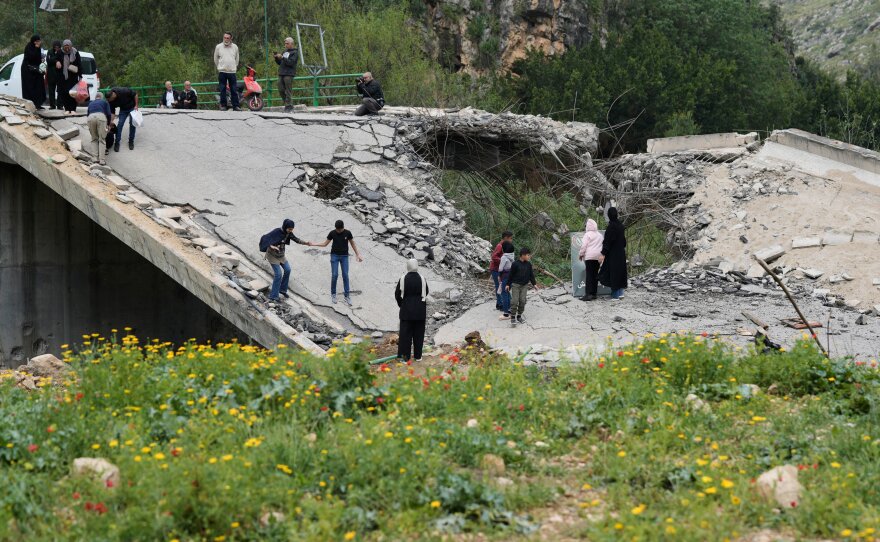 Displaced people cross on foot over a destroyed bridge as they return to their villages following a ceasefire between Hezbollah and Israel, in Tayr Felsay village near the city of Tyre, southern Lebanon, April 19, 2026