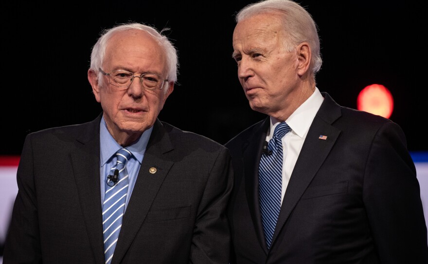 Vermont Sen. Bernie Sanders (left) and former Vice President Joe Biden talk before the Democratic debate.