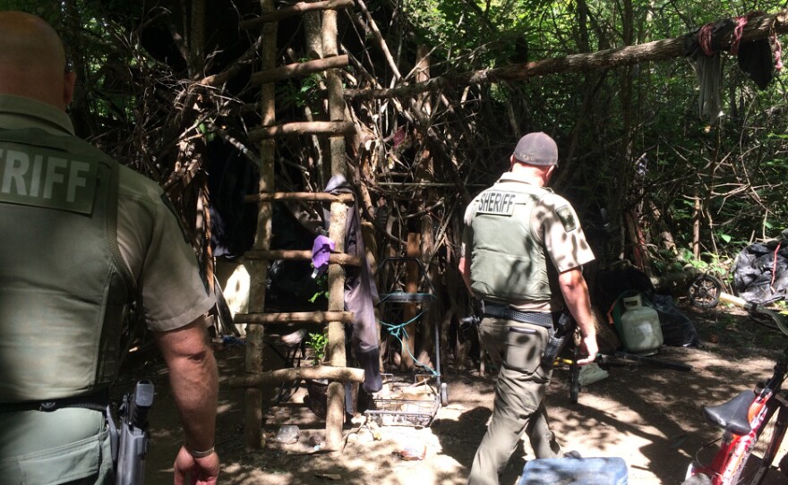 During their patrol of the Bear Creek Greenway, Jackson County Sheriff's deputies walk through a years-old encampment that deputies call "the Hobbit House."