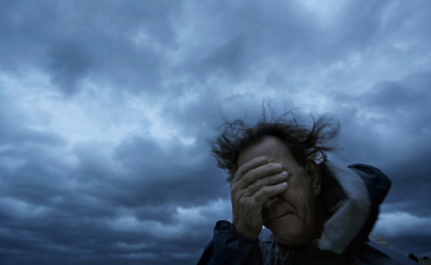 Russ Lewis covers his eyes from a gust of wind and a blast of sand as Hurricane Florence approaches Myrtle Beach, S.C. Even as mandatory evacuation orders were issued, many chose to stay.