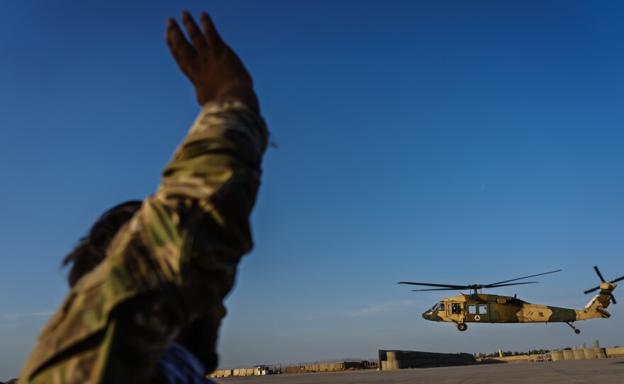 Afghan Army Capt. Rezaye Jamshid waves to a UH-60 Black Hawk aircraft taking off at Kandahar Airbase Afghanistan in May. The Taliban captured helicopters and other military equipment when they overran the Afghan military this month and reclaimed control of the country.