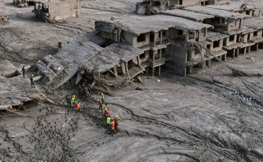 A drone view shows rescue workers inspect the area and damaged structures following recent flash flooding along the Trishuli River in the Devighat area of Nuwakot district, Nepal, Saturday, Aug. 29, 2026.