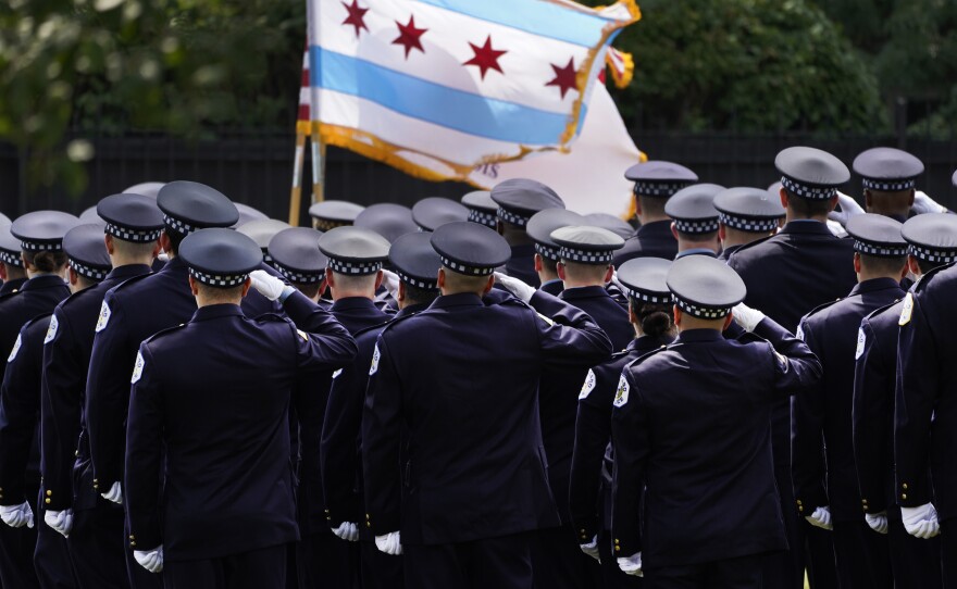 Chicago police officers salute the state flag on Aug. 18.