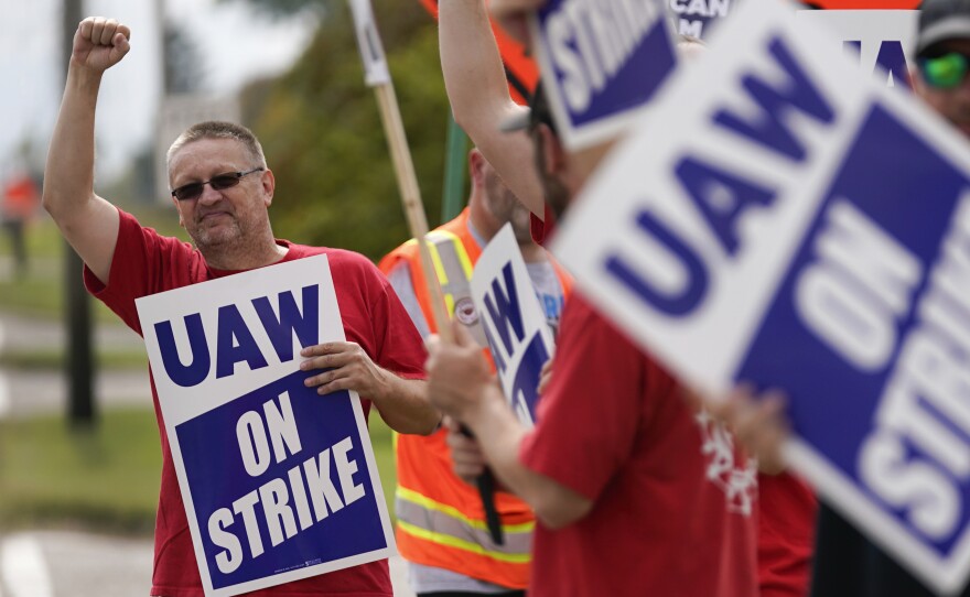 UAW members hold picket signs near a General Motors Assembly Plant in Delta Township, Mich., on Sept. 29, 2023. The UAW is gradually tightening the screws on the Big Three automakers as it pursues new contracts.