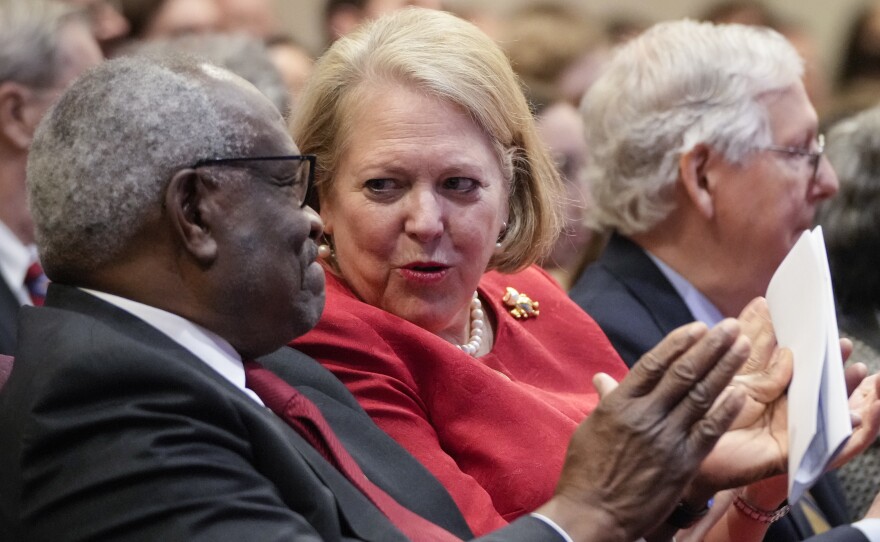 Supreme Court Justice Clarence Thomas talks to his wife, Ginny Thomas, a conservative activist, at the Heritage Foundation on Oct. 21, 2021, in Washington, D.C.