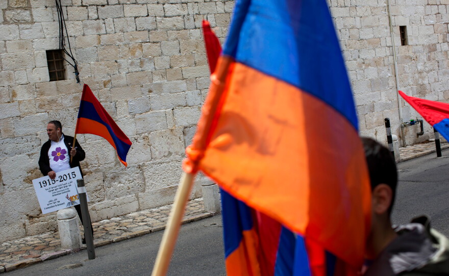 FILE - Armenians hold their national flag during a ceremony to commemorate the mass killings of Armenians by the Ottoman Empire, in Jerusalem, Israel, Friday, April 24, 2015.
