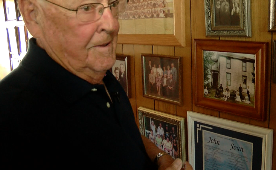 John Rawlings, 90, looks at family photos in his San Diego home, April 21, 2016. 