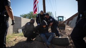 Calexico police officers arrest Hugo Castro who refused to move from the community garden at the Calexico farmworkers encampment, April 7, 2020. Castro is one of the organizers who started the encampment in January. 
