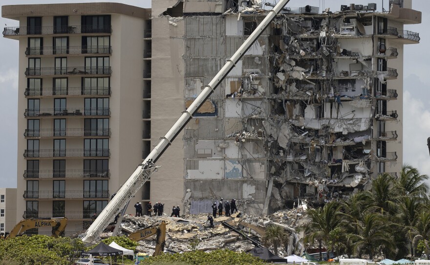 Members of the South Florida Urban Search and Rescue team look for survivors in the partially collapsed 12-story Champlain Towers South condo building in Surfside, Fla., on June 26.