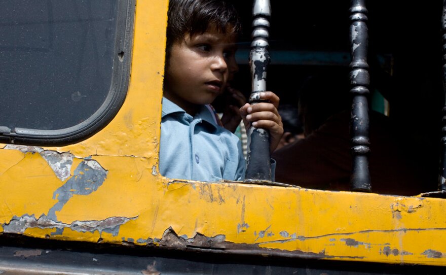Near Aligarh, India, a boy looks out the window of an aging bus on the Grand Trunk Road.