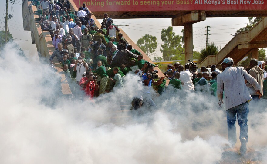School children and activists scramble up a bridge Monday after police try to break up a protest with tear gas at the Langata Road Primary School in Nairobi, Kenya.