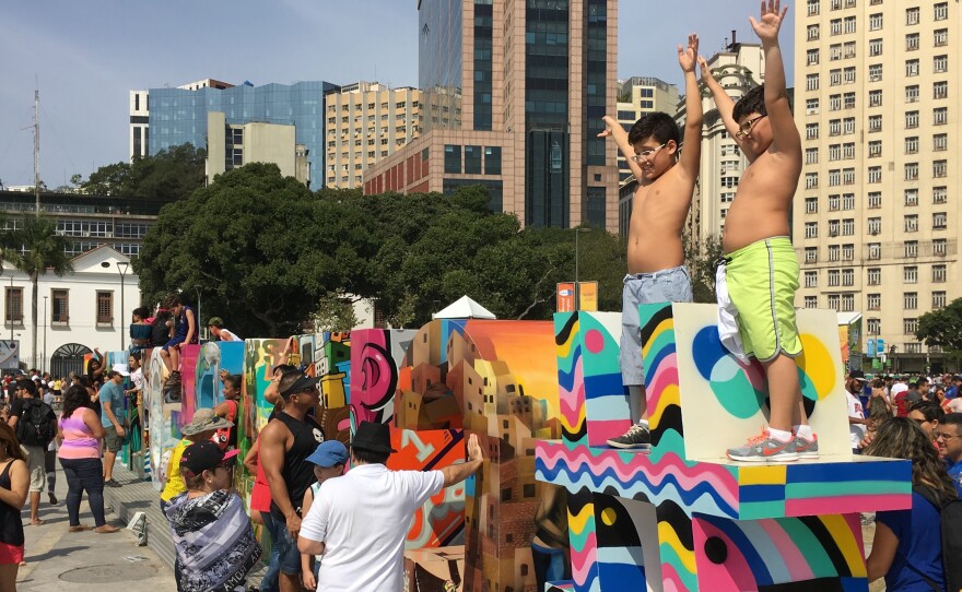 Kids pose for photos on the "Cidade Olimpica" sign along Rio's waterfront.