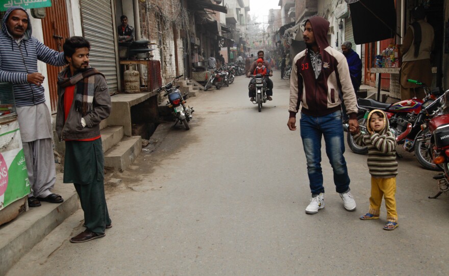 An adult escorts a child in Kasur. Residents say they fear letting their children go out alone.