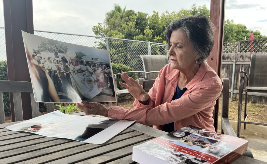 Chula Vista resident Sonia Lopez holds up photos from the Chicano Moratorium in Los Angeles, which she attended, Aug. 28, 2025.