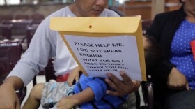 Immigrants from Guatemala seeking asylum look over travel packets as they wait at the bus station after they were processed and released by U.S. Customs and Border Protection, Thursday, June 21, 2018, in McAllen, Texas.