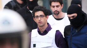 Police in Athens escort two men suspected of sending mail bombs. The men were arrested after bombs addressed to embassies in the Greek capital were intercepted. Greece ordered a 48-hour suspension of overseas deliveries of mail and packages.