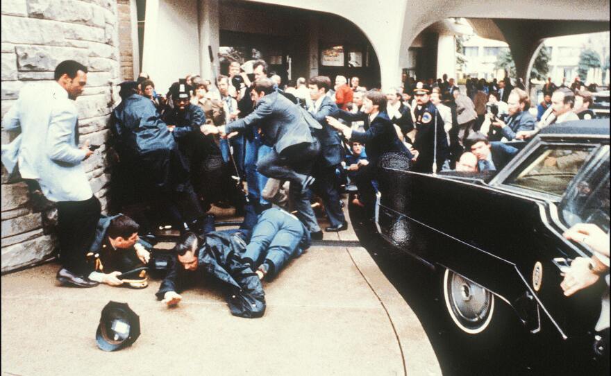 Police and Secret Service agents react to the assassination attempt on President Ronald Reagan in 1981 outside the Hilton Hotel in Washington, DC.