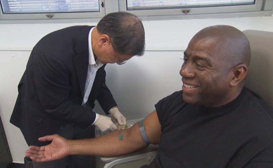 Dr. David Ho, HIV/AIDS specialist, draws blood from Magic Johnson.