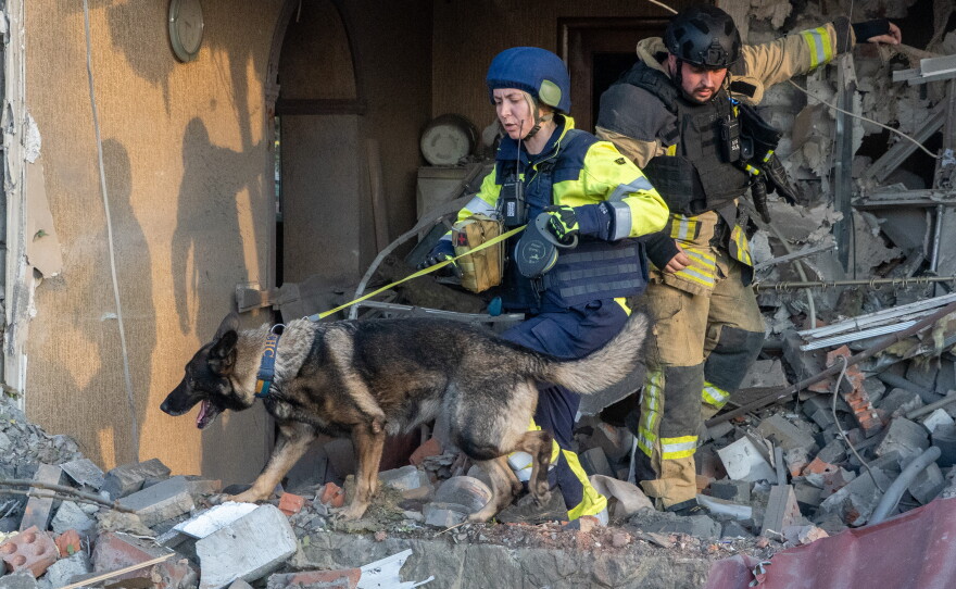 Rescuers with a search dog look for victims among the rubble of a house after a Russian air attack in Kharkiv, Ukraine, Tuesday, Oct. 20, 2026.