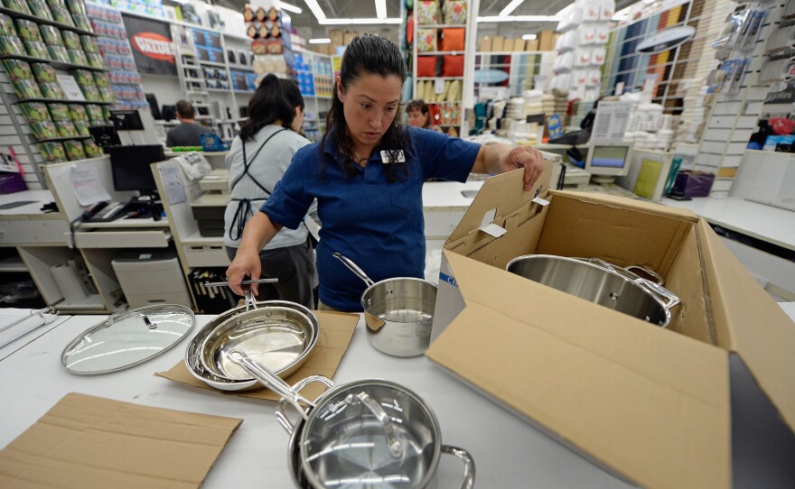 A store manager packs cookware at Bed Bath & Beyond in Los Angeles in April 2013.