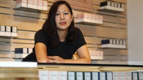 In this Friday, July 26, 2019 photo, Leslie Siu poses for a portrait next to her cannabis products geared toward women on display in Groundswell dispensary in east Denver. Pregnancy started out rough for her. Morning sickness and migraines had her reeling and barely able to function at a demanding New York marketing job, so like rising numbers of U.S. mothers-to-be, she turned to marijuana. “l was finally able to get out from under my work desk,” said Siu, who later started her own pot company and says her daughter, now 4, is thriving.