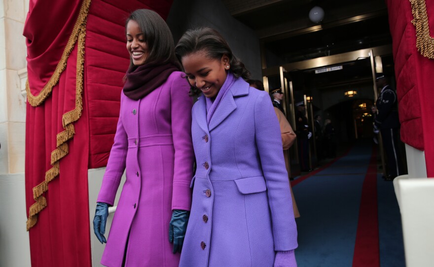 Malia Obama, left, can be seen wearing a J.Crew jacket, while her younger sister, Sasha, wore a coat from American designer Kate Spade.